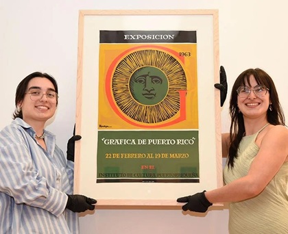 Two students hold up a piece of Latinx art