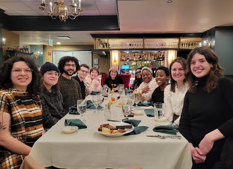Group takes a photo around a table at a restaurant