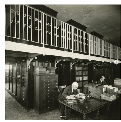 Black and white photo of William J. Holland writing a letter at a desk