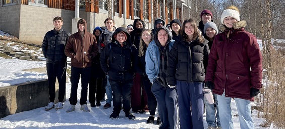 Students take a group photo outside of the Frick Environmental Center