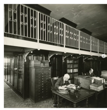 Black and white photo of William J. Holland writing a letter at a desk